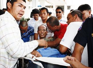 After subduing an irate Suparit from the streets, rescue workers return him to the hospital for treatment.
